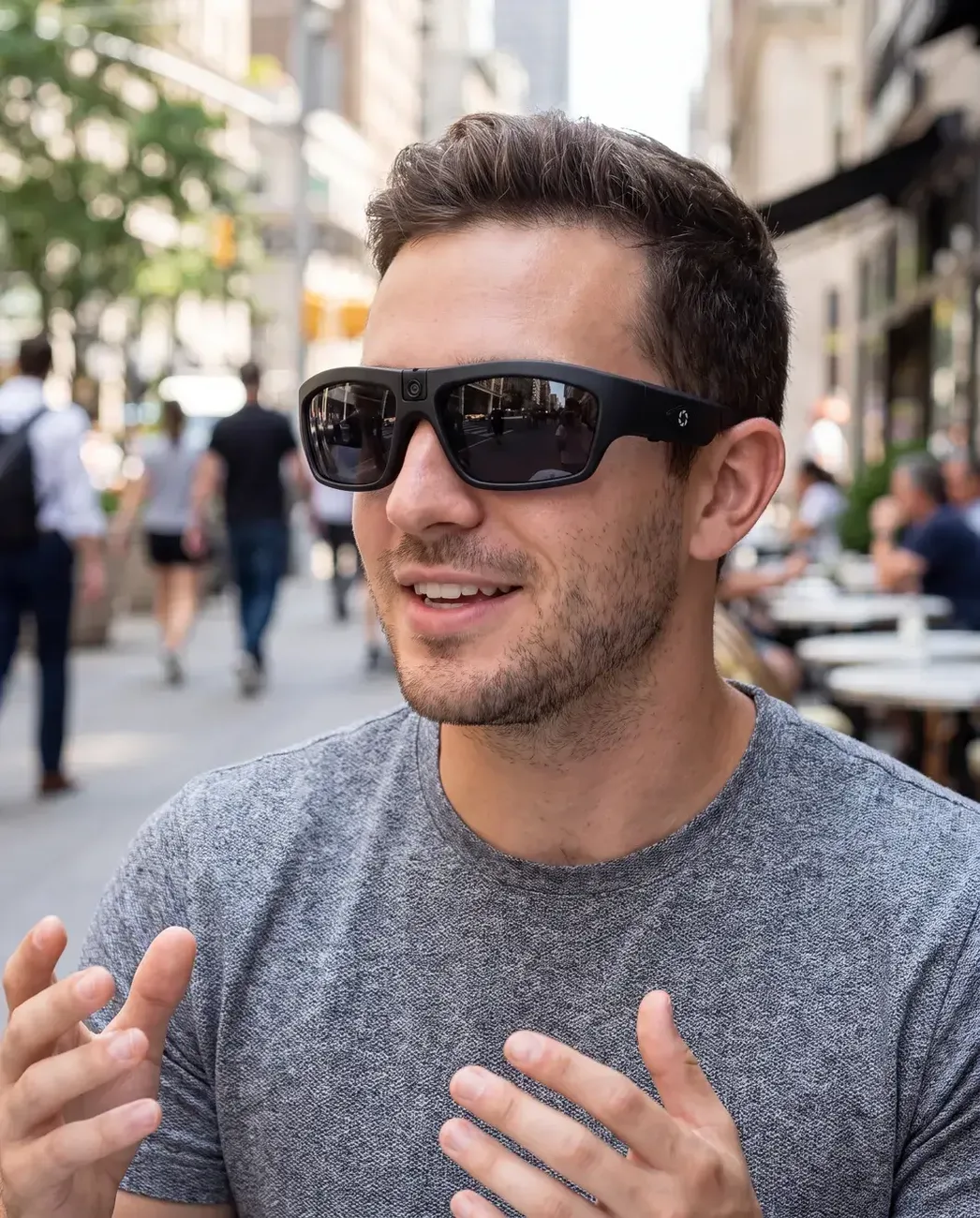 A man wearing the iVUE Denali camera glasses on a city street